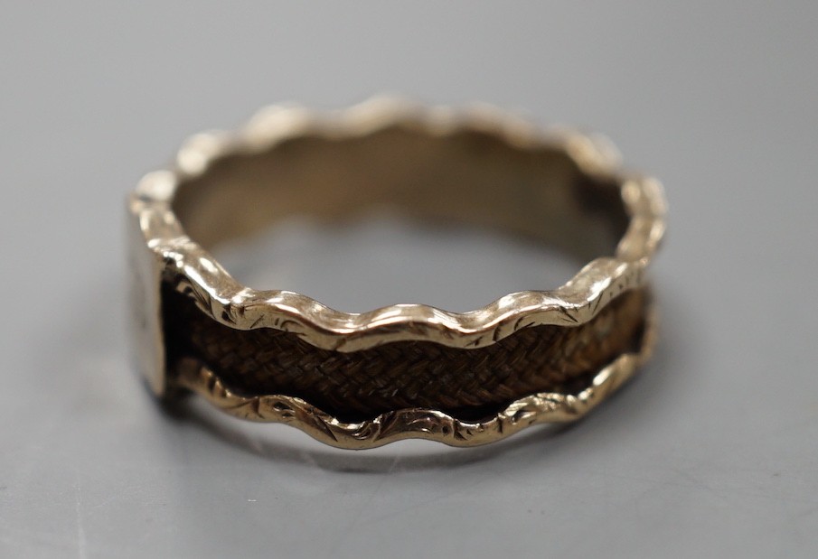 A 19th century yellow metal and plaited hair mourning band, with engraved initial, size N, gross weight 1.7 grams.